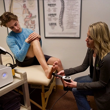 Chiropractor Merrill WI Kate Gress Performing Shockwave Therapy On Patient
